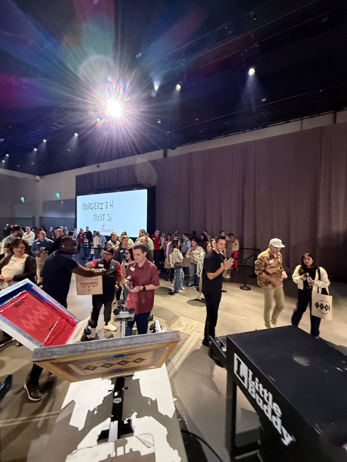 People at an indoor corporate event with stage lighting